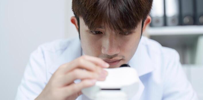 Scientist Focused on Examining Substance Under Microscope in Modern Laboratory Setting photo