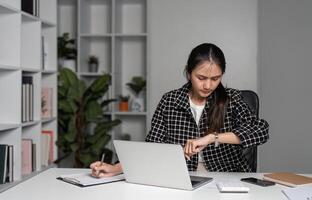 Stressed Business Woman Working Late Hours in Office, Experiencing Exhaustion and Burnout While Managing Deadlines and Tasks photo