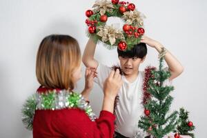 Mother and Son Joyfully Decorating Their Home for Christmas with Festive Wreaths and Ornaments photo