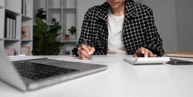 Office Workers Staying Late to Finish Tasks in a Modern Workspace with Laptops and Documents photo