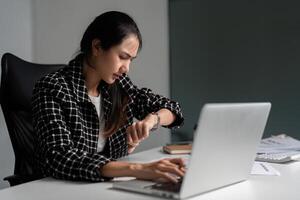 Office Worker Checking Time While Working Late at Night in a Modern Office Environment photo
