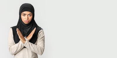 No racism. Angry afro muslim girl in hijab making denial hand gesture, keeping arms crossed over chest, rejecting something bad over gray background photo