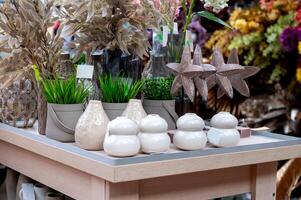 Assorted artificial plants and vases on a display table in a home decor shop. photo