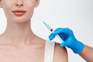 Woman while procedure lip augmentation at cosmetology clinic with beautician. Filler injection for beautiful female lips augmentation with hyaluronic, side view. photo