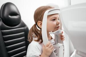 Close-up of a little girl with deep eyes undergoing vision diagnostics using a slit lamp in an ophthalmology clinic. A perfect moment highlighting the importance of caring for children's vision photo