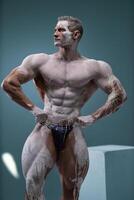 Muscular man with perfect abs posing at studio photo
