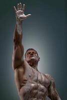 Athletic man posing at the studio with his arm up photo