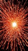 fiery red particles burst from a bright core, spreading outward in a spectacular display across a deep black background, evoking a sense of dynamic energy and heat. photo
