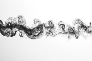 Dark, thick smoke billows horizontally, exhibiting defined edges and subtle transparency while gracefully weaving across a bright white backdrop, creating an abstract appearance. photo