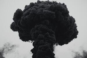 Dense black smoke rises dramatically, forming dark clouds that transition into soft, smoky trails, creating an intense and captivating visual interplay against a white background photo