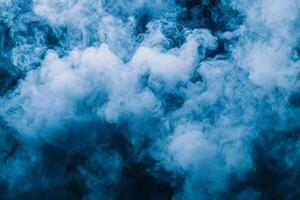 Vivid blue smoke rises gracefully, its thick, textured forms expanding softly against a contrasting white background, creating a dynamic visual experience filled with movement and depth. photo