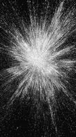 A mesmerizing arrangement of silver particles spirals outward in a vortex, radiating a metallic shimmer against a dark background, evoking a stunning cosmic energy burst. photo