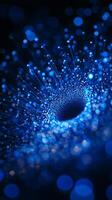 A dynamic composition unfolds as blue particles are arranged in a mesmerizing vortex on a pitch-black canvas, softly glowing and suggesting cosmic energy in motion. photo