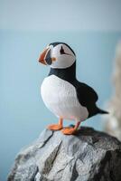 whimsical puffin stands proudly on a grey rocky cliff, its black and white body contrasting beautifully against the light blue sky, embodying a serene coastal atmosphere. photo