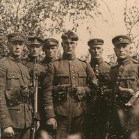 group of World War I soldiers stands together proudly displaying their weapons. Clad in military uniforms they exude a sense of unity and resolve amidst their surroundings. photo