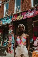 In a lively urban setting an individual showcases their unique fashion sense with vibrant colors surrounded by striking graffiti art under bright daylight. photo