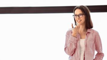 Technology And People Concept. Young female manager in specs using voice command recorder on mobile phone, copyspace photo