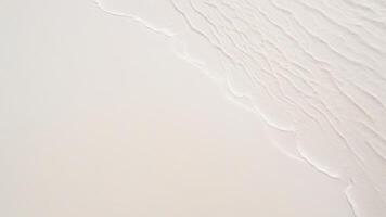 top view of waves on the edge of a white sand beach with texture as a background. photo