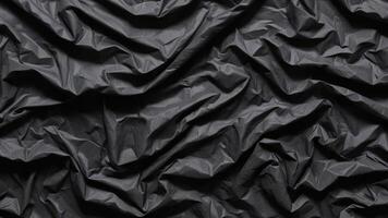 crumpled black plastic texture as background. photo