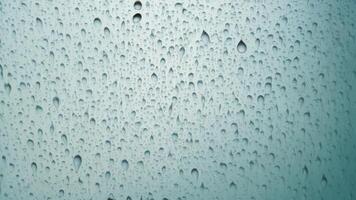 Water droplets slide across the glass surface. photo