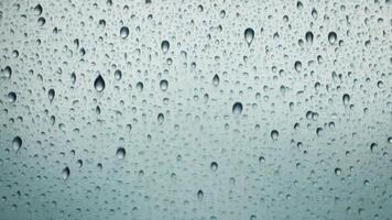 Water droplets slide across the glass surface. photo