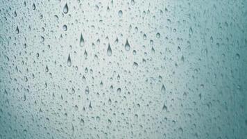 Water droplets slide across the glass surface. photo