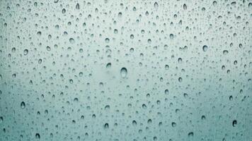 Water droplets slide across the glass surface. photo