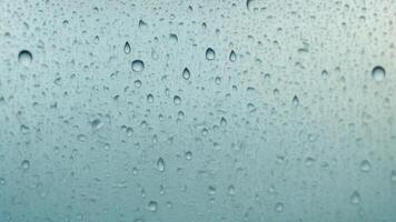 Water droplets slide across the glass surface. photo