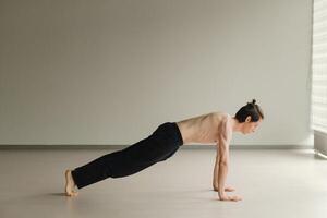 a man with a naked torso does yoga in the gym. the concept of a healthy lifestyle photo