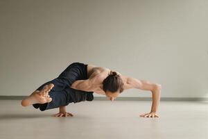 a man with a naked torso does yoga in the gym. the concept of a healthy lifestyle photo