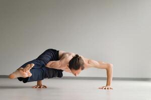 a man with a naked torso does yoga in the gym. the concept of a healthy lifestyle photo