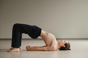 a man with a naked torso does yoga in the gym. the concept of a healthy lifestyle photo