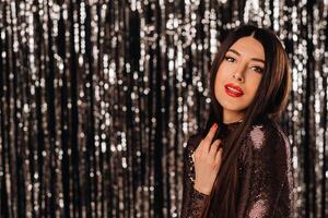 a girl in a shiny jacket on a silver background of New Year's rain photo