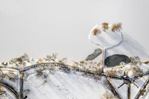 an island on a lake with a bridge in the Winter Loshitsky Park. Minsk, Belarus photo