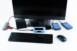 Multiple external hard drives connected to a monoblock on a white background.Computer with hard drive photo