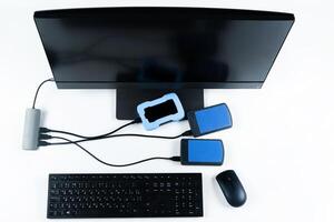 Multiple external hard drives connected to a monoblock on a white background.Computer with hard drive photo