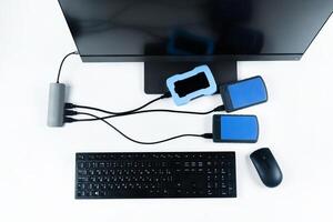 Multiple external hard drives connected to a monoblock on a white background.Computer with hard drive photo