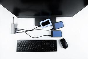 Multiple external hard drives connected to a monoblock on a white background.Computer with hard drive photo