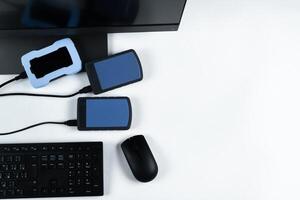 Multiple external hard drives connected to a monoblock on a white background.Computer with hard drive photo