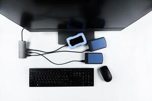 Multiple external hard drives connected to a monoblock on a white background.Computer with hard drive photo