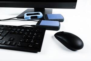 Multiple external hard drives connected to a monoblock on a white background.Computer with hard drive photo