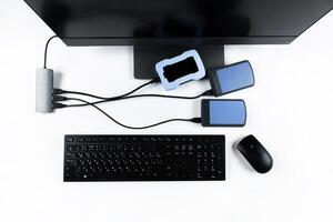 Multiple external hard drives connected to a monoblock on a white background.Computer with hard drive photo