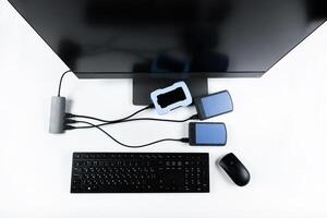 Multiple external hard drives connected to a monoblock on a white background.Computer with hard drive photo