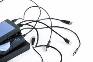 many external hard drives with wires lie on a white background. Hard drives on isolate. photo