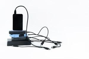many external hard drives with wires lie on a white background. Hard drives on isolate. photo