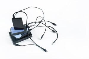 many external hard drives with wires lie on a white background. Hard drives on isolate. photo