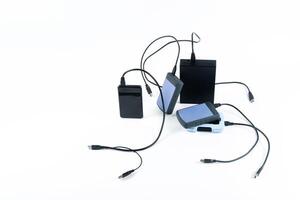 many external hard drives with wires lie on a white background. Hard drives on isolate. photo