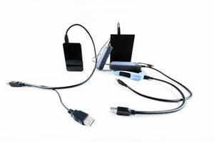 many external hard drives with wires lie on a white background. Hard drives on isolate. photo
