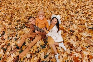 Father and mother with son walking in the autumn Park. A family walks in the Golden autumn in a nature Park. photo