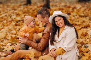 Father and mother with son walking in the autumn Park. A family walks in the Golden autumn in a nature Park. photo